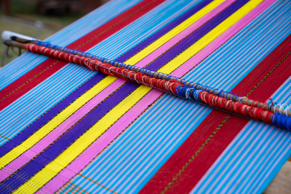 Hilos de urdimbre de colores tensados en un telar de cintura